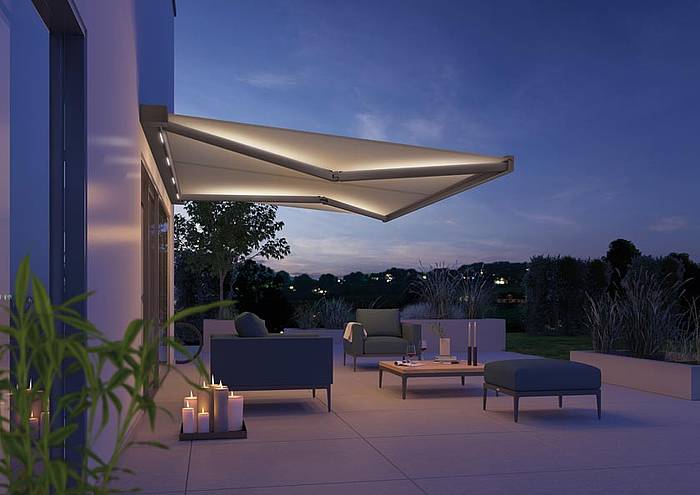 Moderne Terrasse mit hellgrauem Sonnenschutz und stimmungsvoller Beleuchtung am Abend